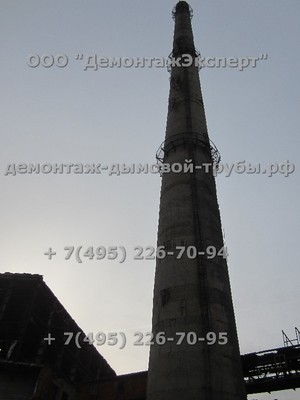 Демонтаж 100 метровой железобетонной дымовой трубы чётко между зданиями на химическом производстве