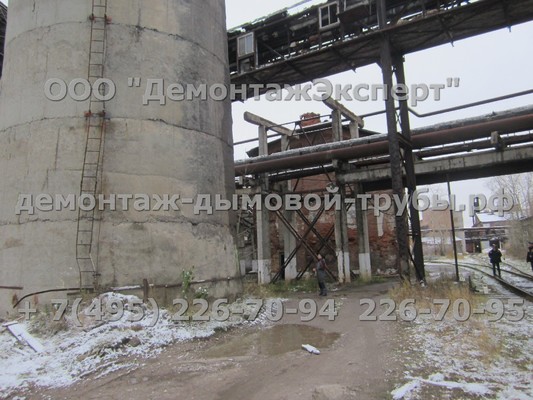 Демонтаж 100 метровой железобетонной дымовой трубы чётко между зданиями на химическом производстве
